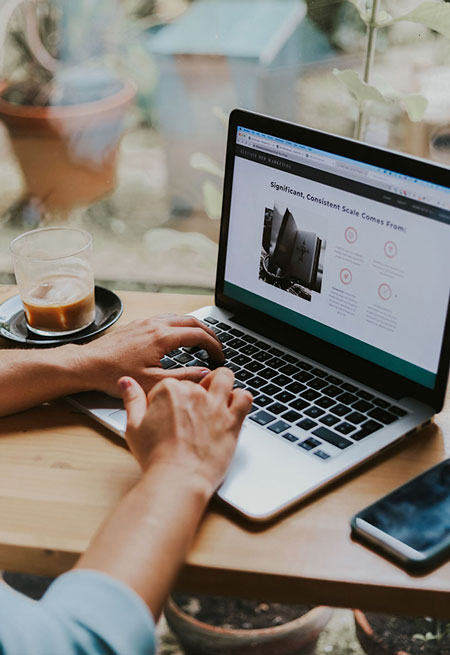 Frannie Coggeshall sits in front of her laptop looking at a sales page