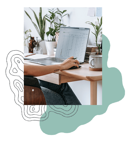 A woman sits at her desk looking at Facebook ad results on her laptop