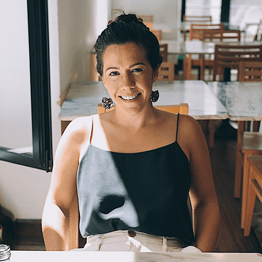 Frannie Coggeshall sits at a table smiling at the camera