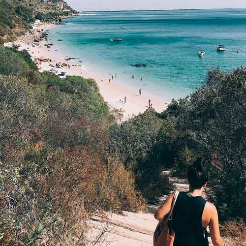 Frannie Coggeshall walks down a steep hill leading to the ocean