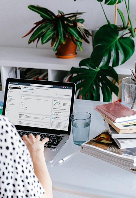 Woman checking Facebook ads stats on a laptop